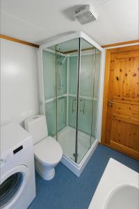 a bathroom with a toilet and a glass shower at Sentralt og elegant opphold nær alt in Lillehammer +4 photos