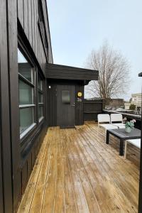 a wooden deck with a bench on a house at Sentralt og elegant opphold nær alt in Lillehammer