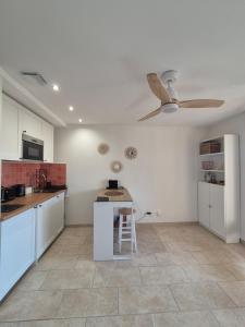 滨海萨纳里Cozy studio proche plages et gare的厨房配有白色橱柜和吊扇