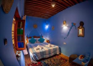 a bedroom with a bed in a blue room at Riad misk lile fez in Fès