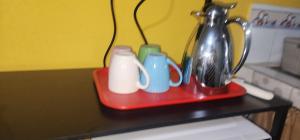 ein rotes Tablett mit Tassen und Besteck auf einem Tisch in der Unterkunft Colibriest Bed & Breakfast in Intibucá