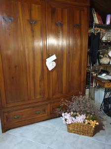a large wooden cabinet with a basket of flowers next to it at Creativ hause in San Giuliano Terme