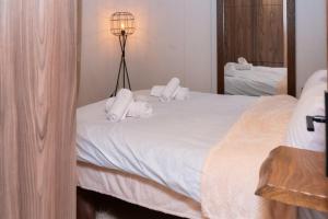 Bacco Village House في موزاكيون: غرفة نوم بسرير مع شراشف ومناشف بيضاء