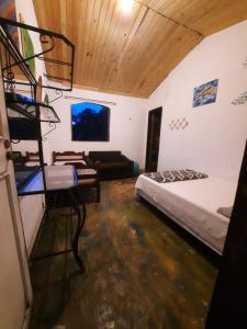 ein Schlafzimmer mit einem Bett und einer Couch in einem Zimmer in der Unterkunft Passeio Bom in Juquei