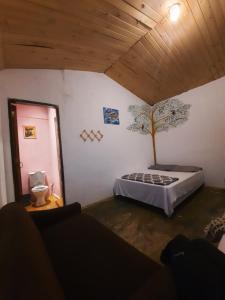 ein Schlafzimmer mit einem Bett und einem Baum an der Wand in der Unterkunft Passeio Bom in Juquei