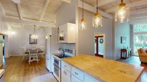 a kitchen with white cabinets and a table in a room at Meet Me At Sunset in Jekyll Island