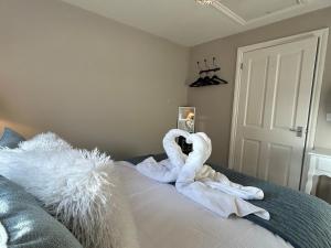 a bedroom with swans made out of towels on a bed at The Lodge - Elegant Peaceful Countryside Escape in Bishops Cannings +23 photos