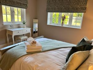 a bedroom with a bed with towels on it at The Lodge - Elegant Peaceful Countryside Escape in Bishops Cannings