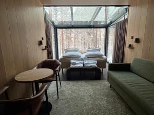 ein Zimmer mit zwei Betten und einer Couch und einem Fenster in der Unterkunft Balder Luxury Lodge & Glass Igloos in Levi