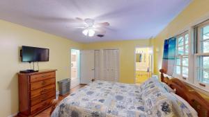 een slaapkamer met een bed en een plafondventilator bij A Hidde Gem Duplex in Jekyll Island