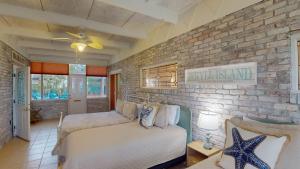 a bedroom with a bed and a brick wall at Meet Me At Sunset in Jekyll Island