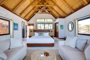 - une chambre avec un lit et deux canapés dans l'établissement Kanu Private Island Belize, à Placencia