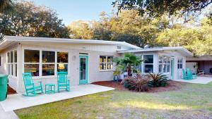 a house with blue chairs in the front yard at Sea Haven Duplex A in Jekyll Island