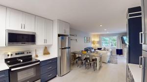 a kitchen with white cabinets and a table with chairs at Sea Haven Duplex A in Jekyll Island