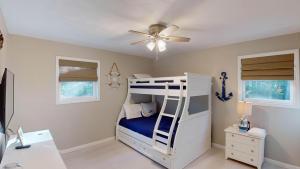 a bedroom with a bunk bed with a ceiling fan at Sea Haven Duplex A in Jekyll Island