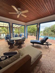a living room with a couch and a ceiling fan at Casa Corazón - Spacious 6 Bedroom Beachfront Villa with Pool Pier in Riversdale