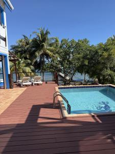 a swimming pool on a deck next to the water at Casa Corazón - Spacious 6 Bedroom Beachfront Villa with Pool Pier in Riversdale