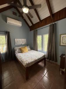 a bedroom with a bed in a room with windows at Casa Corazón - Spacious 6 Bedroom Beachfront Villa with Pool Pier in Riversdale