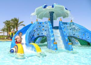 a boy on a water slide in a water park at JAZ Makadi Saraya Resort in Hurghada