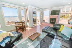 Centrally Located 3Br Oceanfront W Great Value & Views By Beachview Rentals في شاطئ نيوبورت: غرفة معيشة مع أريكة ومدفأة