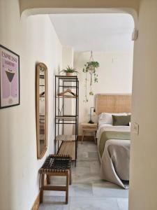 a living room with a bed and a mirror at Rooms Vita in Granada