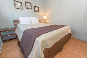 Centrally Located 3Br Oceanfront W Great Value & Views By Beachview Rentals في شاطئ نيوبورت: غرفة نوم بسرير كبير وموقف ليلي