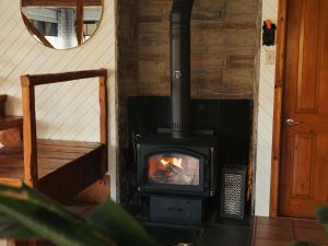 a wood stove in a room with a mirror at Le Selby in Dunham