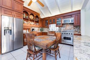 7Br Beachfront Retreatstunning Ocean Views & Walkable Fun By Beachview Rentals في شاطئ نيوبورت: مطبخ مع طاولة خشبية وثلاجة من الفولاذ المقاوم للصدأ