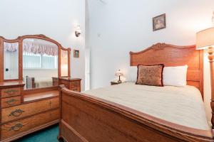 7Br Beachfront Retreatstunning Ocean Views & Walkable Fun By Beachview Rentals في شاطئ نيوبورت: غرفة نوم مع سرير خشبي وخزانة