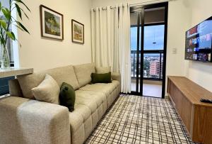 a living room with a couch and a tv at 2-bedroom apartment, Home Office and panoramic view in São Carlos