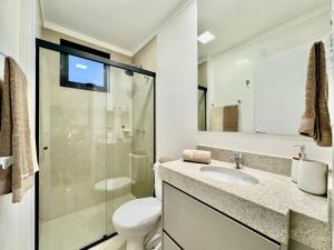 a bathroom with a toilet and a sink and a shower at 2-bedroom apartment, Home Office and panoramic view in São Carlos +11 photos