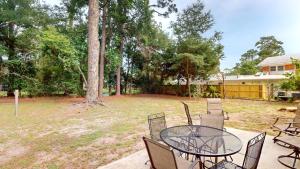 a patio with a table and chairs in a yard at Reflection in Jekyll Island