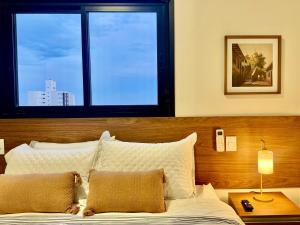 a bedroom with a bed with a large window at 2-bedroom apartment, Home Office and panoramic view in São Carlos