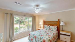 a bedroom with a bed and a window at Reflection in Jekyll Island