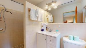 a bathroom with a toilet and a sink and a mirror at Reflection in Jekyll Island +14 photos
