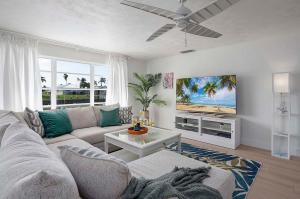 Una sala de estar con un sofá y un televisor de pantalla plana. en Lovers Key - Waterfront Stunner, Walk to Town!, en Cabo Coral