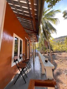 a porch of a house with chairs and tables at Modo home in Komodo