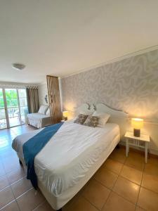 a bedroom with a large white bed with two lamps at Studio de rêve dans un village de vacances - Entièrement rénové 2025 - Clim rénovée 2025 in Sainte-Luce +33 photos