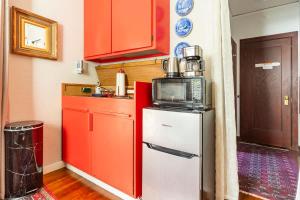 une cuisine avec des armoires rouges et un micro-ondes au-dessus d'un réfrigérateur dans l'établissement Serene Private Suite Patio Upscale Berkeley, à Piedmont