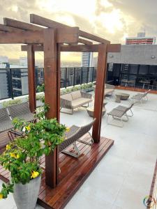 a rooftop patio with chairs and tables on a building at Compact Time 1402 in Tambaú