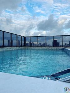 a swimming pool on the roof of a building at Compact Time 1402 in Tambaú