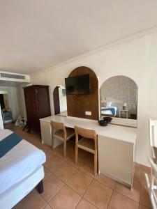 a bedroom with a bed and a desk with a television at Studio de rêve dans un village de vacances - Entièrement rénové 2025 - Clim rénovée 2025 in Sainte-Luce