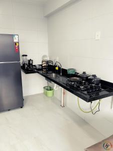 a kitchen with a counter with pots and pans on it at Compact Time 1402 in Tambaú