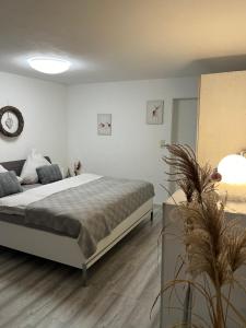 a bedroom with a bed and a clock on the wall at Ferienwohnung Dünnebacke in Schmallenberg