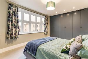 a bedroom with a bed and two windows at Sea Croft in Worthing