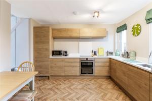 a kitchen with wooden cabinets and a wooden table at Sea Croft in Worthing