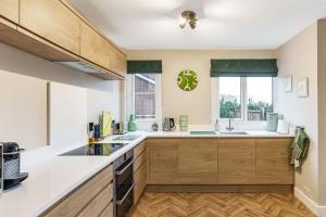a kitchen with wooden cabinets and a window at Sea Croft in Worthing +19 photos