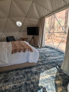 um quarto com uma cama numa tenda em نيوم العلا em Al Ula