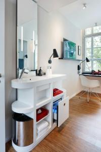 Un baño con un lavabo blanco y un escritorio. en citizenM Amstel Amsterdam, en Ámsterdam