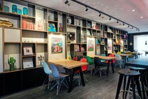 Un restaurante con mesas, sillas y estanterías. en citizenM Amstel Amsterdam, en Ámsterdam